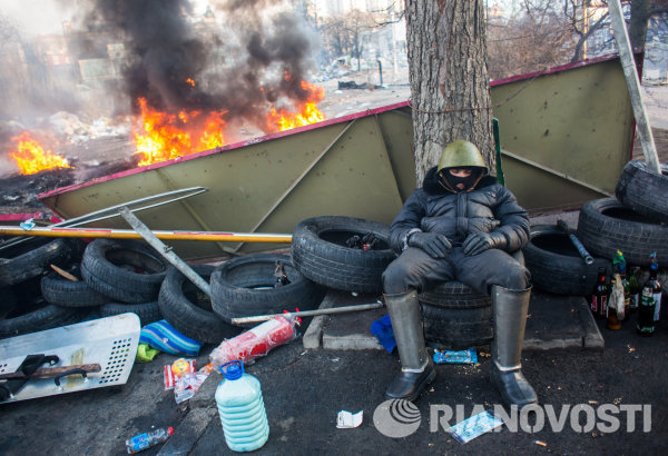 Сторонник оппозиции спит на баррикаде на улице Институтской в Киеве.