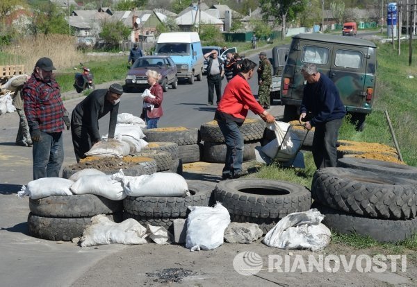Местные жители строят баррикаду из мешков с песком на новом блокпосту возле села Былбашовка под Славянском