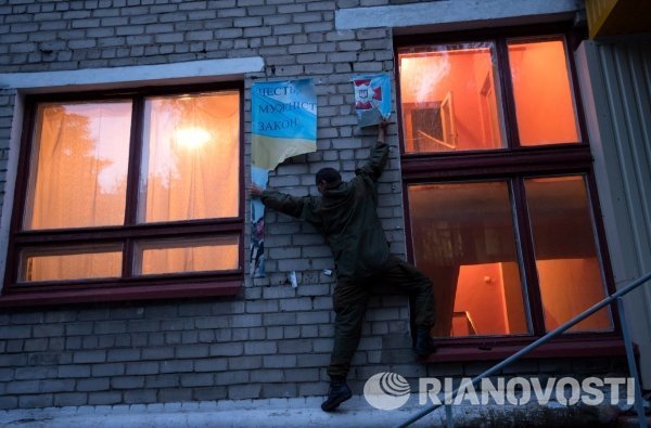 Ополченцы ДНР срывают украинские плакаты на территории воинской части № 3004, занятой ими в результате штурма.