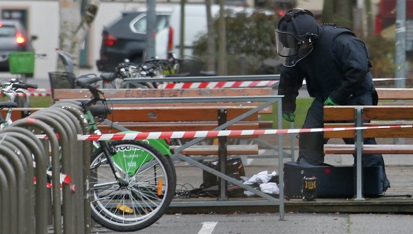 Полицеский осматривает подозрительный чемодан в Страсбурге