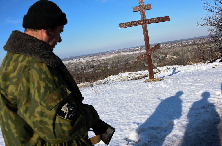 Ополченец ЛНР перед православным крестом
