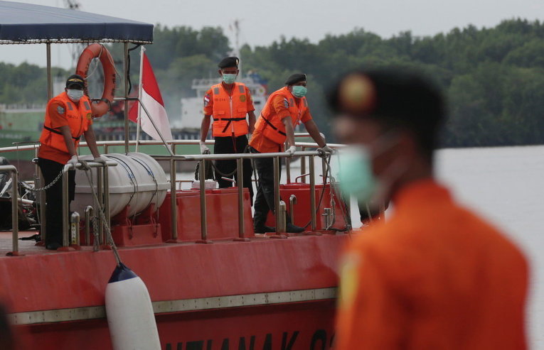 Члены операции по поиску обломков самолета AirAsia в порту Кумай в Индонезии