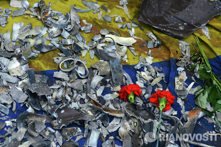Цветы и осколки, собранные с места авиаудара украинских ВВС, лежащие на флаге, испачканном кровью у здания областной администрации в Луганске.
