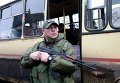 Украинский силовик охраняет автобус, в котором будут эвакуированы жители Дебальцево