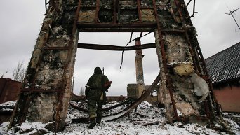 Ополченец на фоне разрушенного здания в Углегорске