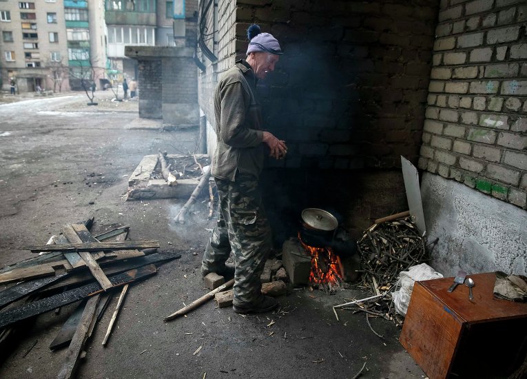 Местный житель готовит кушать возле дома в Дебальцево