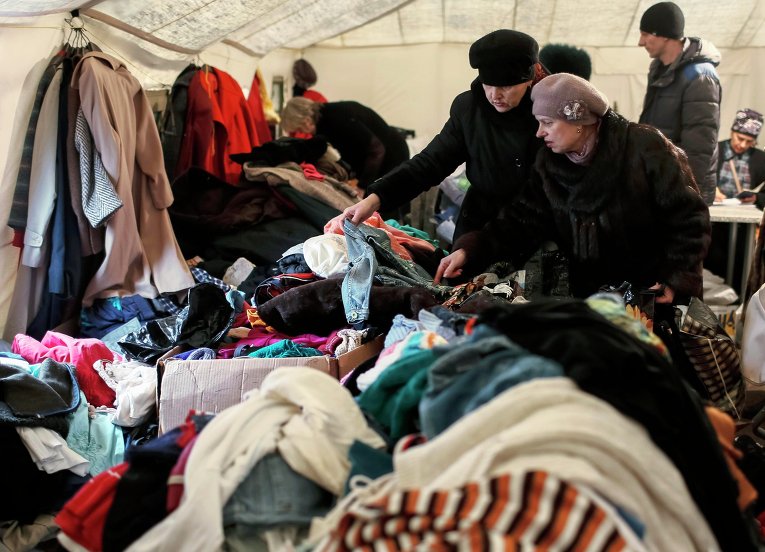 Беженцы выбирают бесплатную одежду в волонтерском центре в Славянске