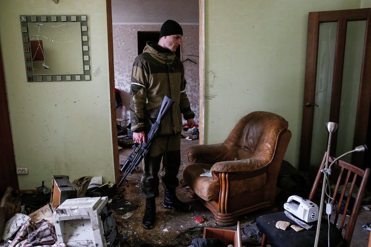 Ополченец проверяет дом, где украинские военные занимали одну из своих позиций в Углегорске