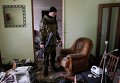 Ополченец проверяет дом, где украинские военные занимали одну из своих позиций в Углегорске