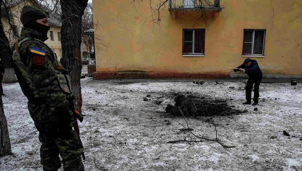 Военный и местный житель у снаряда, упавшего в Краматорске
