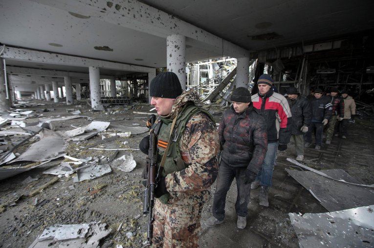 Ополченец и военнопленные украинские силовики в разрушенном аэропорту Донецка, 26 февраля 2015