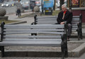 Пожилой мужчина сидит на скамейке. Архивное фото