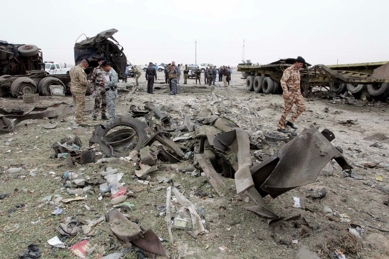 Иракские военные осматривают место очередного теракта, произошедшего 18 марта