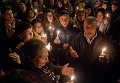 Тунисцы с зажженными свечами молятся у въездных ворот в музей Бардо, где десятки людей были убиты боевиками