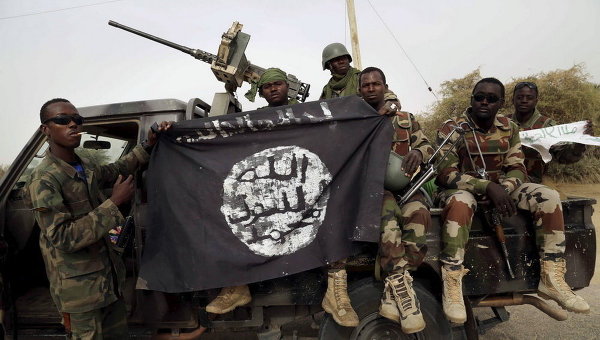 Нигерийские солдаты держат флаг Боко Харам, который они недавно захватили