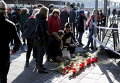 Люди возлагают цветы на месте стрельбы в Гетеборге