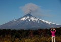 Мужчина наблюдает за дымом вулкана Вильяррик, в столице Чили - Пуконе