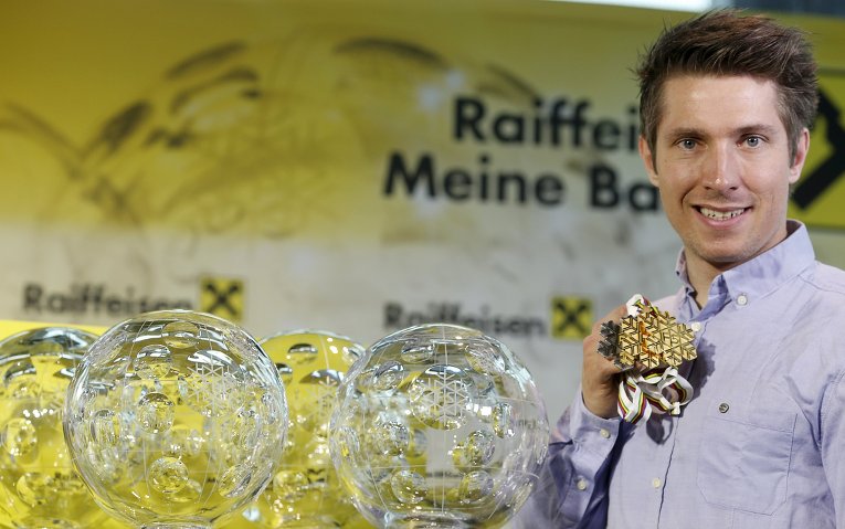 Победитель Кубка мира по лыжам Марсель Хиршер позирует со своим трофеем