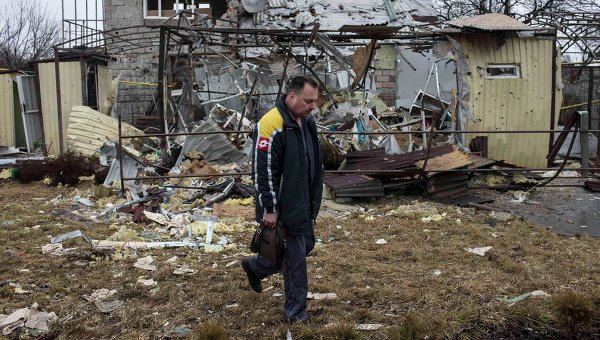 Мужчина проходит мимо разрушенного в результате обстрела дома в жилом районе Донецка (5 марта 2015 года)