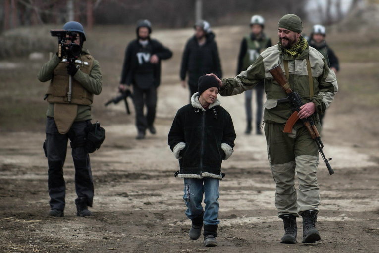 Украинский военнослужащий и школьник в селе Чермалык, 26 февраля 2015 г