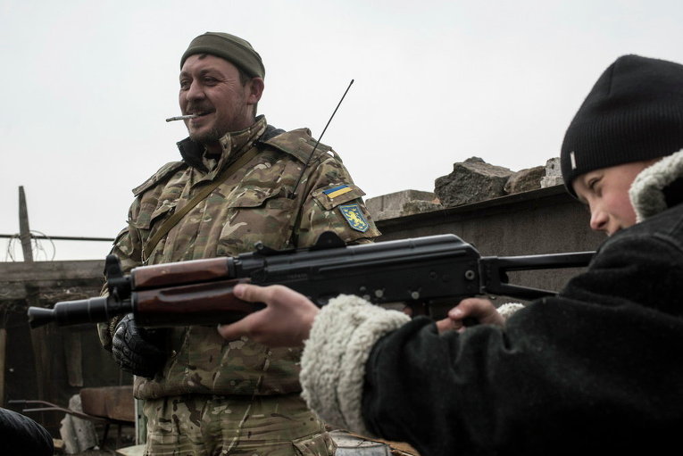 Мальчик с винтовкой и украинский военнослужащий в селе Чермалык, 26 Февраль 2015 г