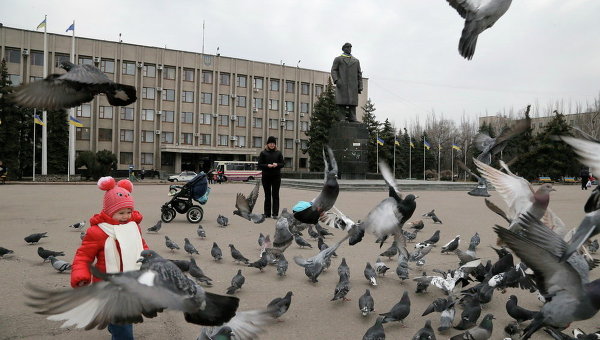 Ребенок играет с голубями на центральной площади Славянска. Архивное фото
