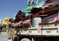 Йеменец загружает свои вещи в кузов грузовика в Сане
