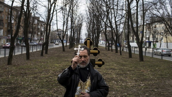 Православный священник во время поминовения жертв среди гражданского населения, погибших при обстреле в Донецке, 21 марта 2015