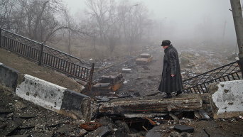 Женщина на разрушенном мосту близ аэропорта в Донецке