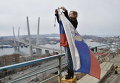 Женщина во Владивостоке привязывает траурную черную ленту в память о погибших с траулера Дальний Восток