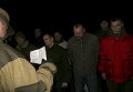 Ополченец читает список пленных военных, которые передаются украинской стороне в поселке Марьинка в Донецкой области