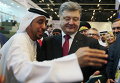 Петр Порошенко смотрит на свою селфи с представителями СМИ Эмиратов на Международной выставке IDEX в Абу-Даби