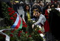 Люди возлагают цветы к памятнику перед зданием парламента в Тбилиси в годовщину трагических событий 9 апреля 1989 года, когда советские войска разогнали мирную демонстрацию