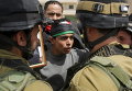 Палестинский демонстрант спорит с израильскими солдатами во время акции протеста по случаю Дня палестинских заключенных в селе Маасара 17 апреля 2015 года