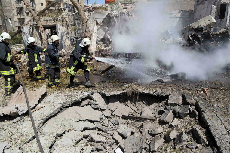 Участники гражданской обороны тушат пожар после авиаударов в Алеппо, 17 апреля 2015
