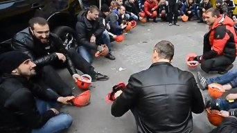 Шахтеры стучат шахтерскими касками по тротуарной плитке в Киеве в ходе акции протеста