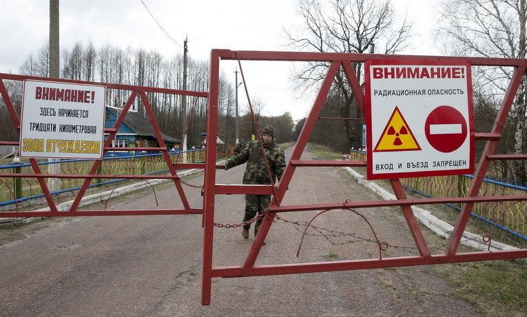 Сотрудник закрывает ворота на входе в зону отчуждения вокруг Чернобыльской АЭС, 21 апреля 2015
