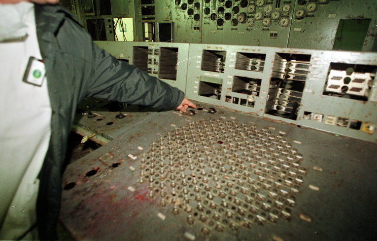 Рабочий показывает выключатель питания в контрольной комнате четвертого реактора Чернобыльской АЭС, 10 ноября, 2000 г