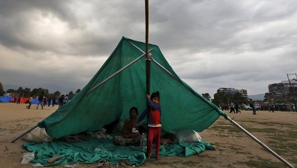 Непальская семья в импровизированном укрытии на открытой местности после землетрясения в Катманду