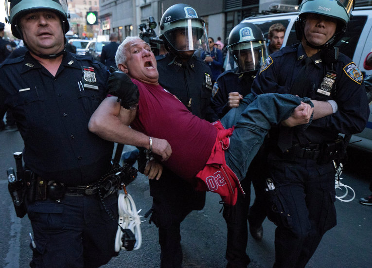 Сотрудники полиции несут человека в Нью-Йорке