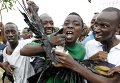Протестующие несут мертвого ворона, скандируя антиправительственные лозунги в Бурундии