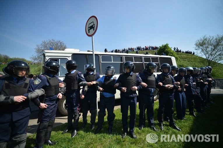 Работники МВД охраняют автобус с задержанными членами радикальных организаций, прорывавшихся на митинг КПУ 1 мая