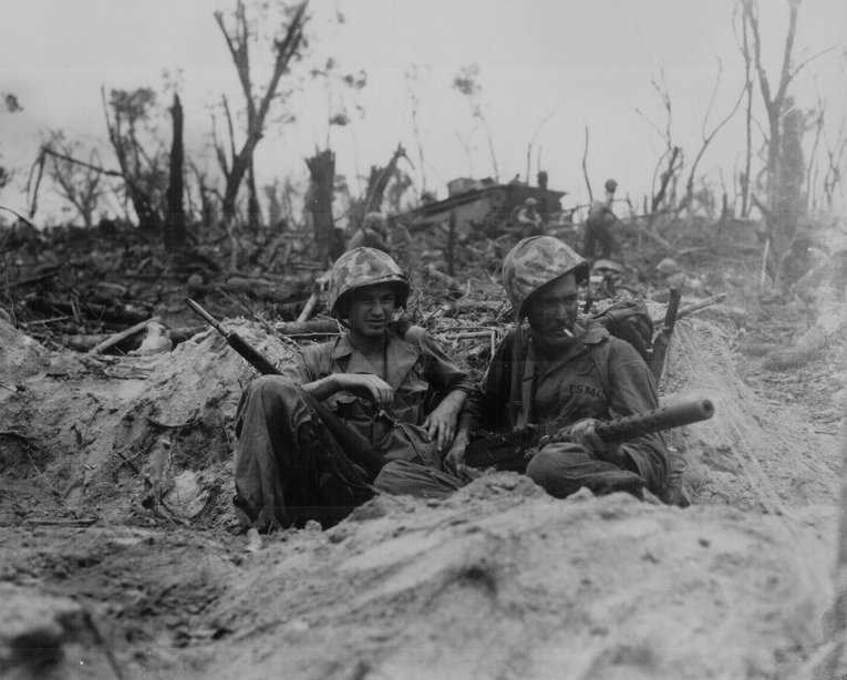 Рядовые морской пехоты Дуглас Лайтхарт и Джералд Чарчбай во время перекура. Битва за Пелелиу, 1944 год.