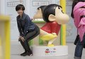 Посетитель позирует с моделью Crayon Shin во время выставки в Joy City в Пекине. Выставка, на которой представлены пятьдесят моделей японской мультипликации, будет работать с 18 апреля по 22 июня.