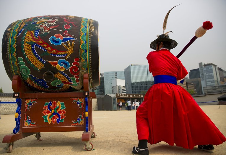 Дворцовая стража бьет в барабан перед дворцом Кенбоккун во время церемонии смены караула. Сеул, Южная Корея.