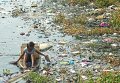 Женщина собирает мусор из реки в филиппинском городе Навотас
