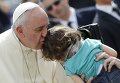 Папа Римский Франциск целует ребенка во время богослужения на площади Святого Петра в Ватикане