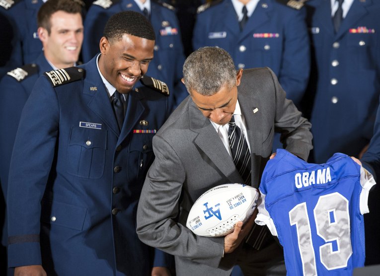 Президент США Барак Обама шутит с футболистом Военно-воздушной академии Кристианом Спирсом.
