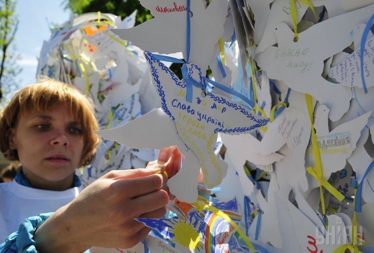Девочка украшает бумажным голубем инсталляцию Голубь Памяти и Мира, приуроченную к 70-летию Победы