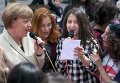 Канцлер Германии Ангела Меркель поет со студентами Рентгена во время ее визита в школу в Берлине.
